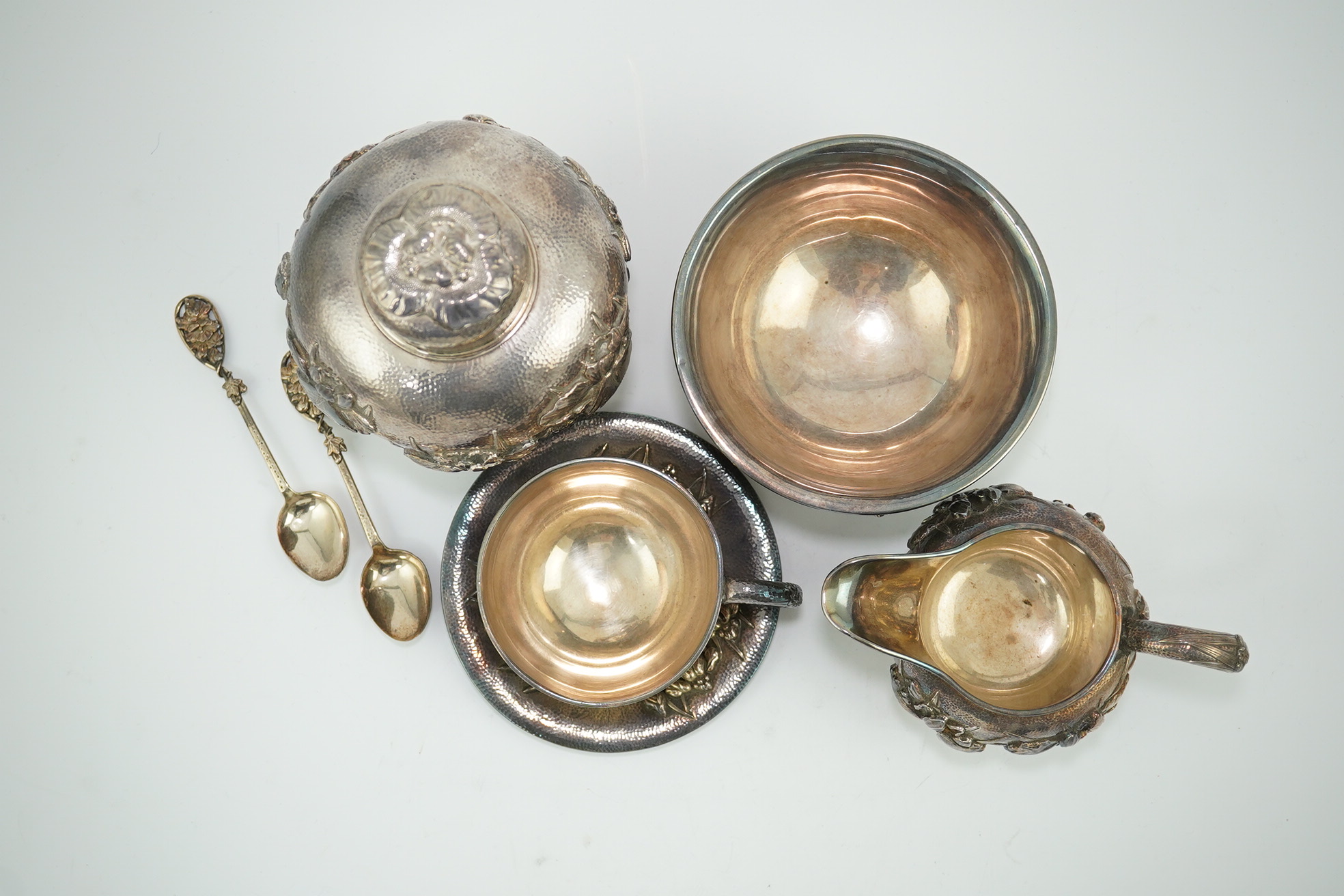 An early 20th century Japanese Meiji period planished silver matched? part tea set comprising a tea caddy with covers, sugar bowl, cream jug and tea cup and saucer